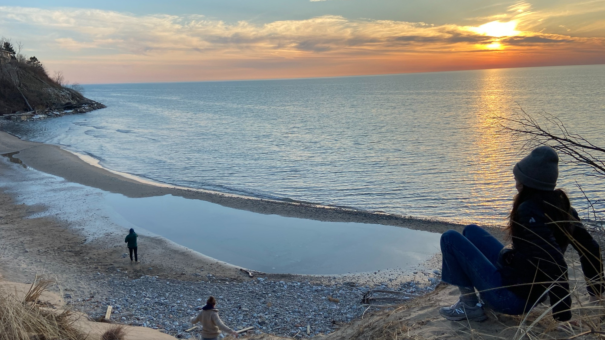 Family watching the waves comes in and the sun setting over Lake Michagan
