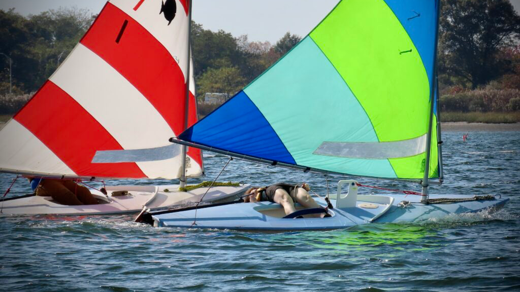 Child hiking out on a sunfish sailboat
